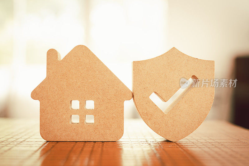 木屋模型和房地产保险构思，还有小盾图标。房屋灭失和火灾保险，建筑火灾保险概念。
