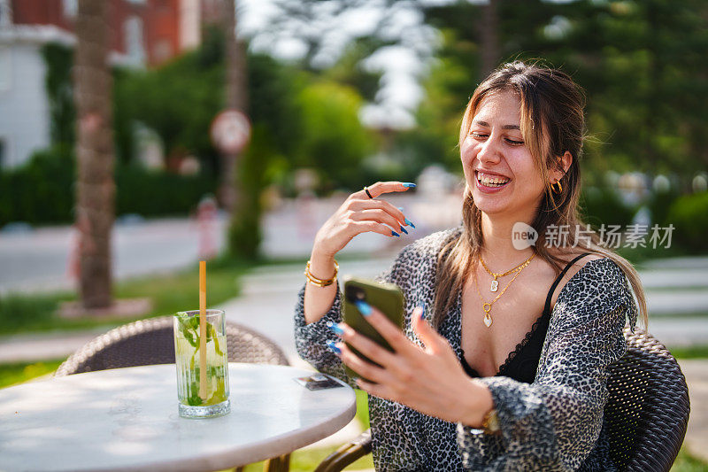 女人边玩手机边喝莫吉托