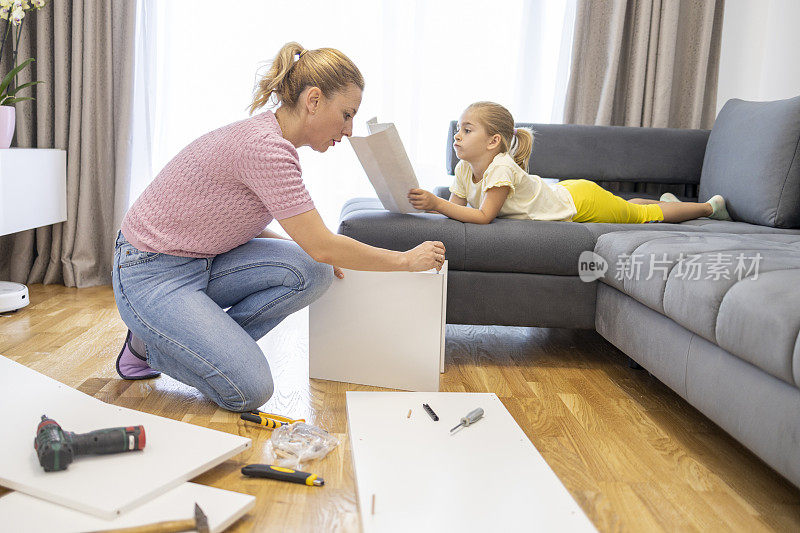 孩子在客厅里帮妈妈组装家具