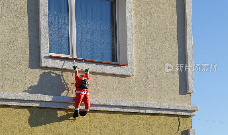 一个圣诞老人雕像挂在窗户上。
