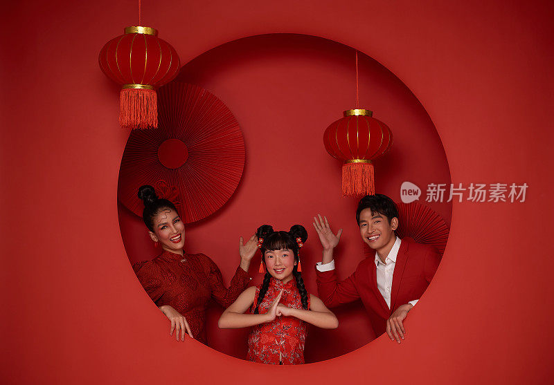 快乐的亚洲家庭穿着红色休闲服装，用传统的红色背景装饰，祝贺2024年中国新年快乐。