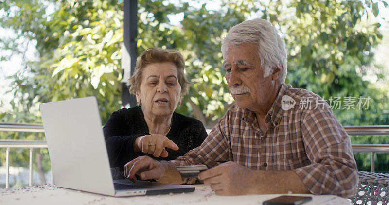 老年夫妇在使用笔记本电脑网上购物时遇到欺诈问题