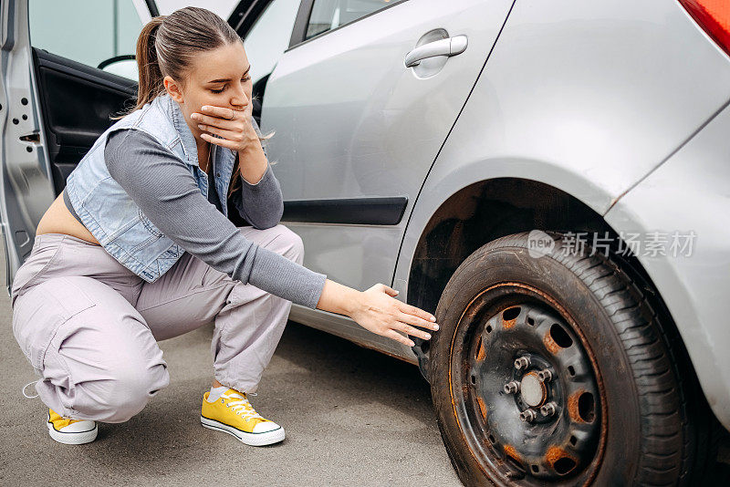 一个女人在路上担心车胎漏气了