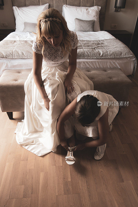 伴娘帮助新娘穿上婚礼鞋