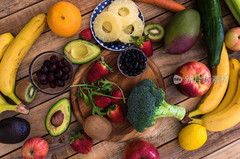 木桌上各种各样的水果和蔬菜，从上方拍摄