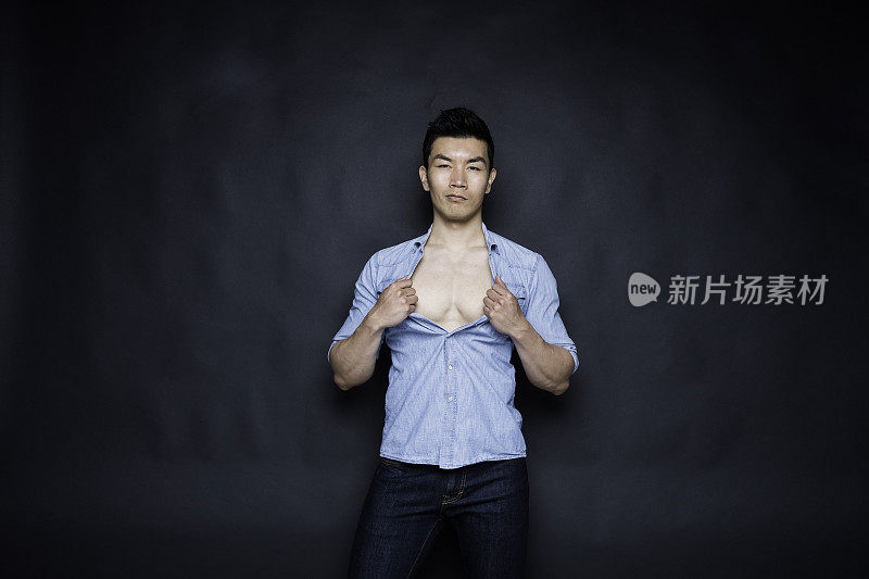性感的亚洲男人穿着一件蓝色衬衫脱衣