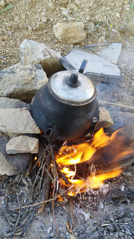 用水壶在营火上烧热咖啡和茶