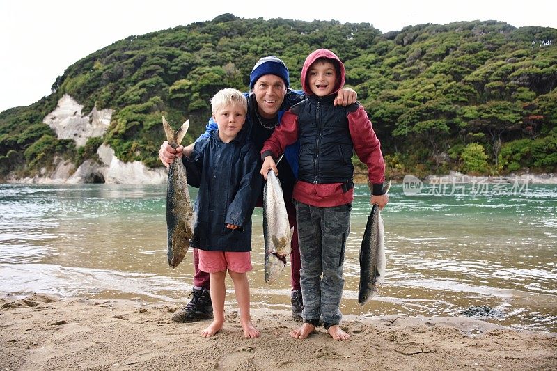 孩子和父亲在海岸岩石上钓鱼