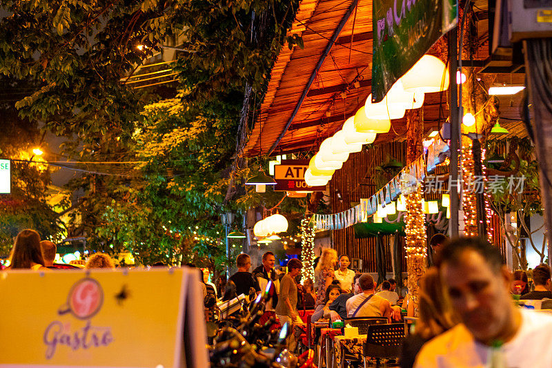 曼谷市的街头市场，有街头小吃、酒吧和商店。夜景，人们走在路上，购买食物，鸡肉饭或油炸昆虫。