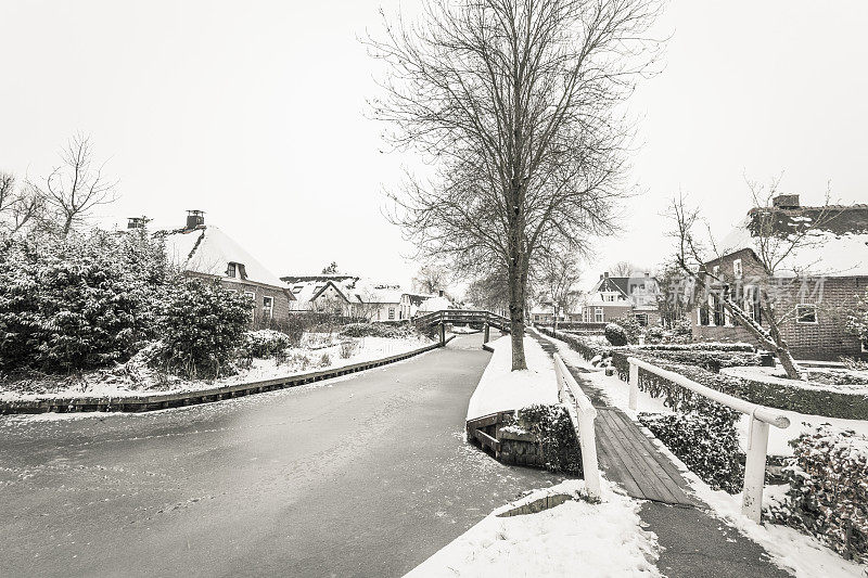 在一个寒冷但美丽而平静的冬天，Giethoorn村的运河和积雪