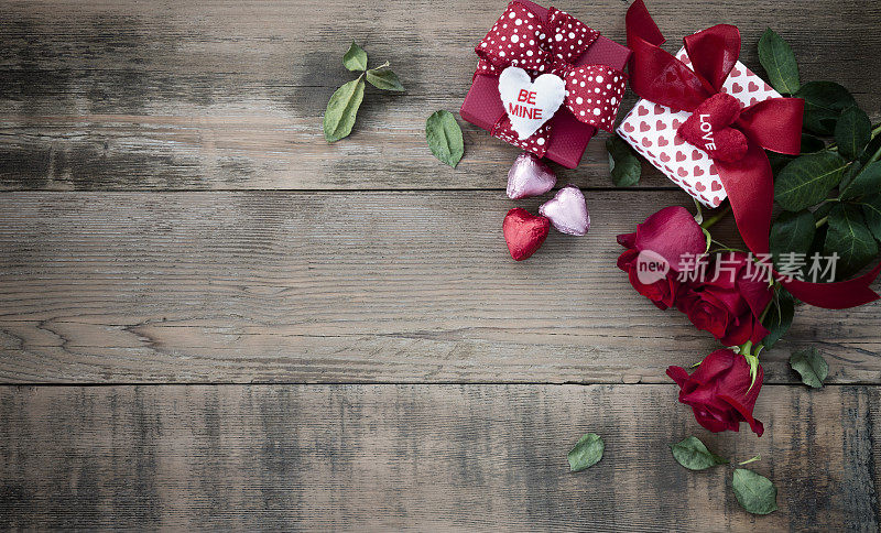 情人节礼物与巧克力和玫瑰在一个古老的木材背景