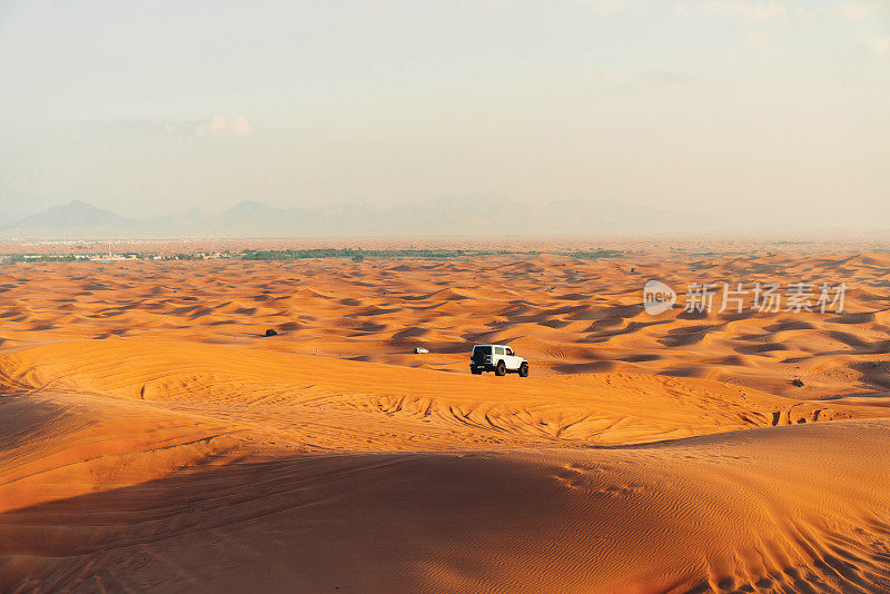 在沙漠的沙丘上行驶的汽车