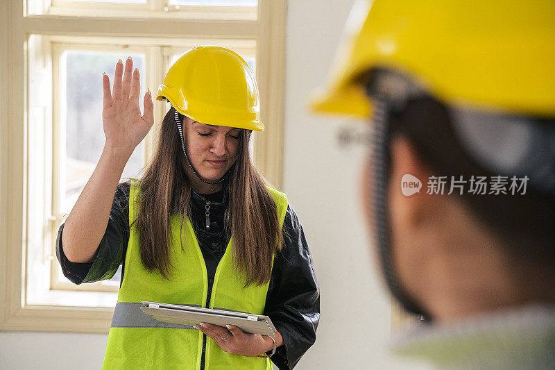 家居装饰。一个年轻的企业家和一个建筑师在一个住宅楼的工地上一起讨论和工作。千禧世代。