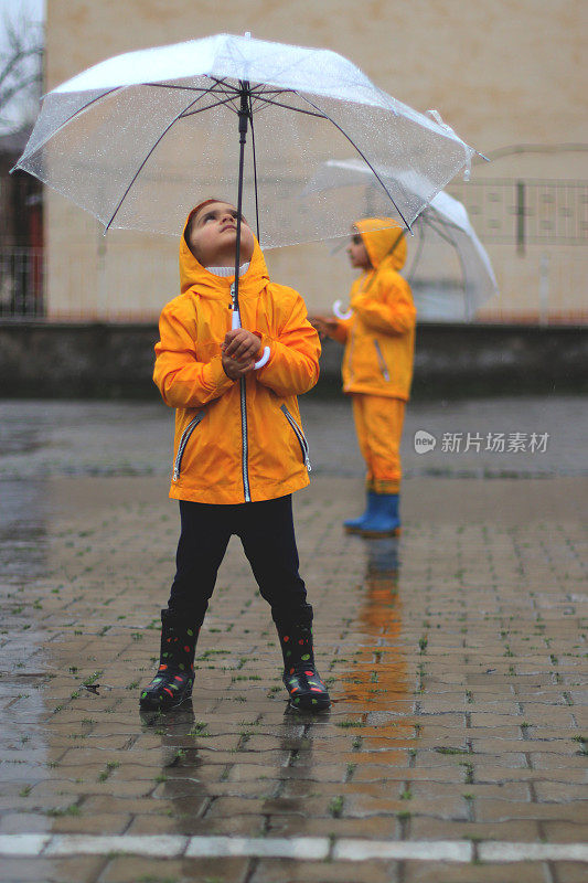 小女孩撑着雨伞在雨中