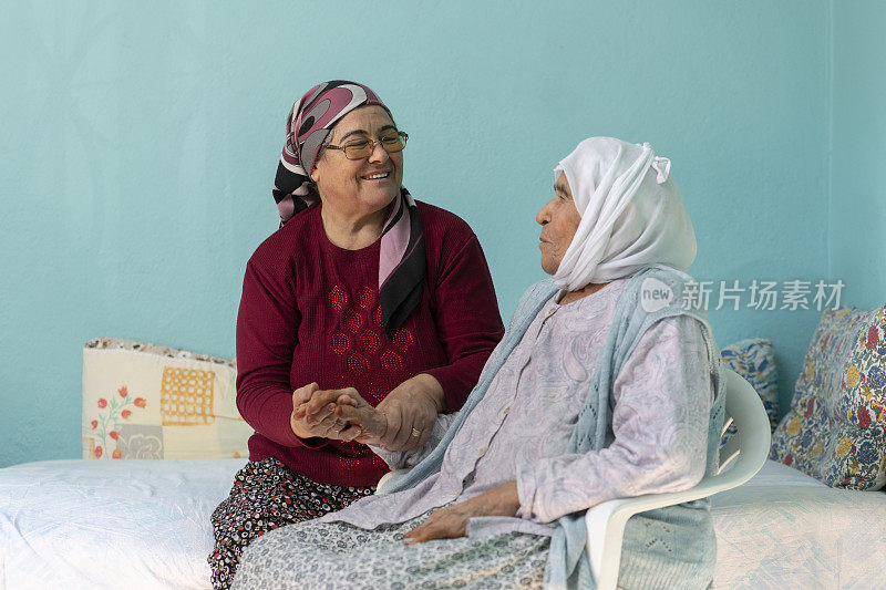 成熟的穆斯林妇女在斋月拜访她年迈的母亲