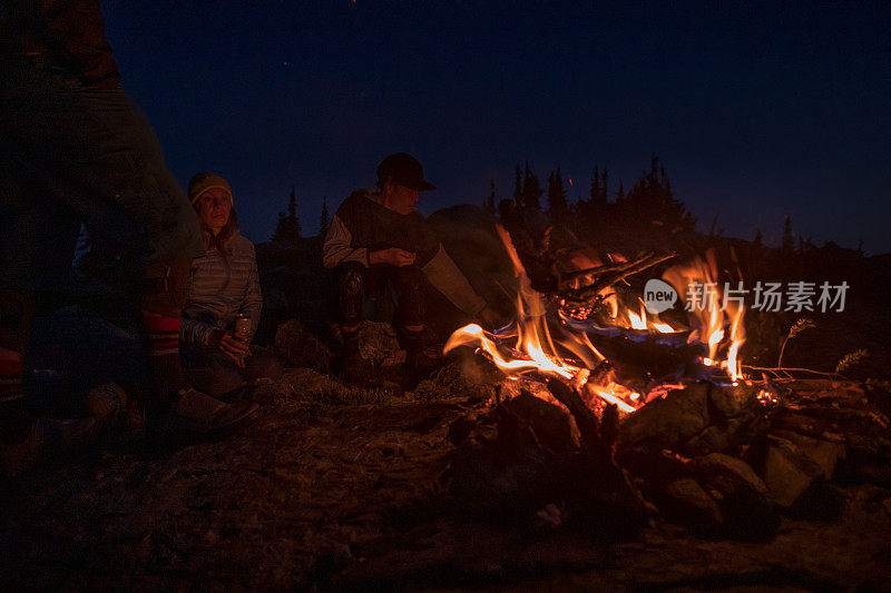 朋友们在晚上露营的时候围着火。