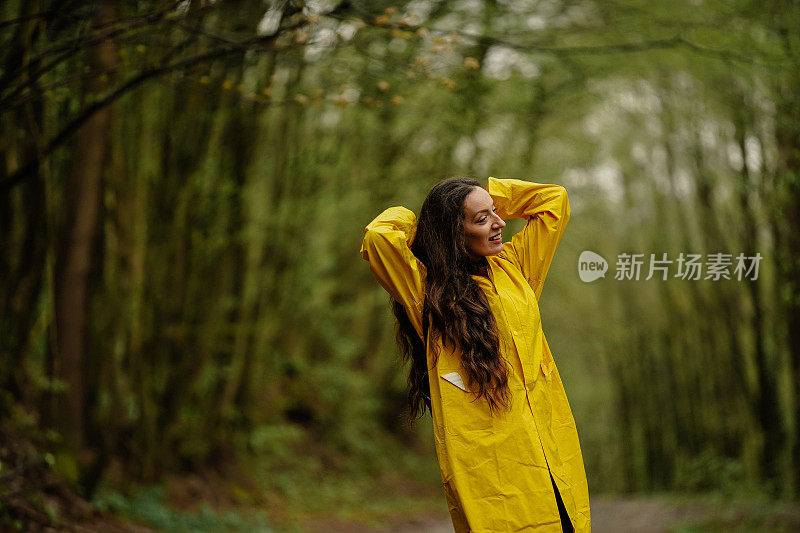 雨中穿着黄色雨衣的年轻女子