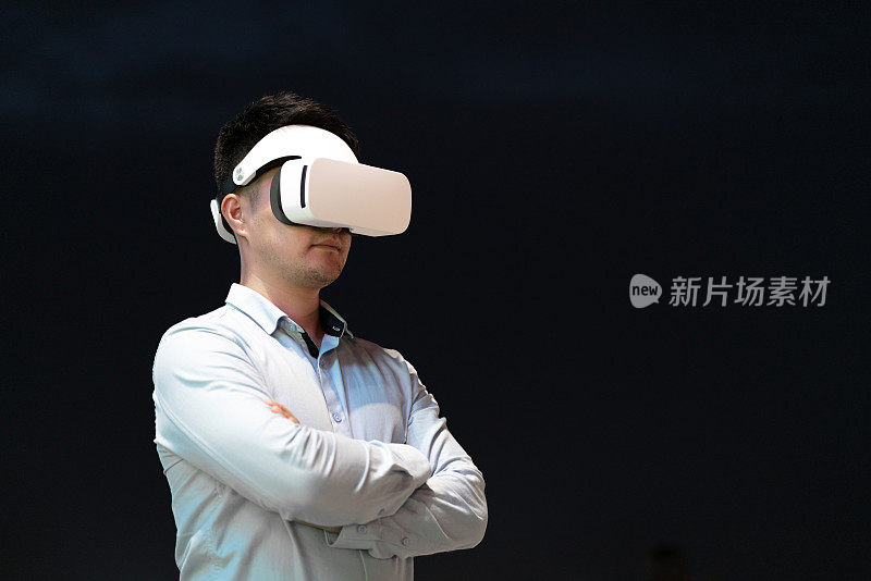 一名中年男子戴着虚拟现实模拟器在夜空中挥舞双臂