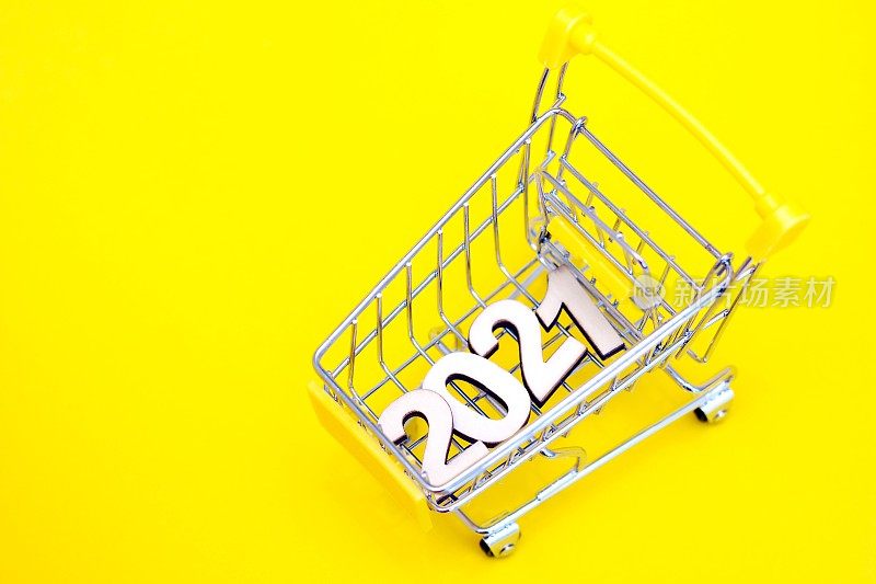 黄色背景的超市玩具车上的数字“2021”。