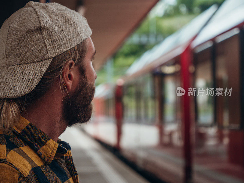 男人在车站等火车，侧视