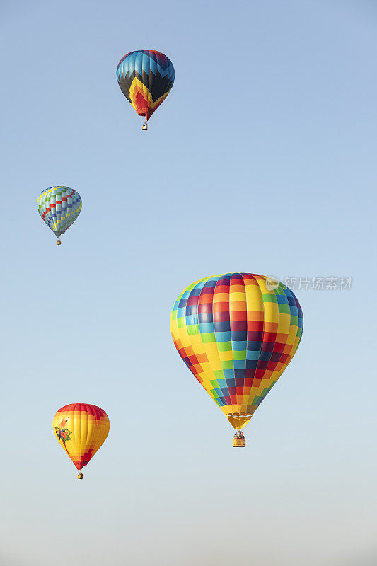 四个热气球在蓝天上飞行