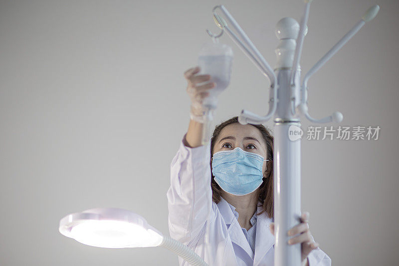 亚洲华人美容师，用注射器从医疗容器中取药
