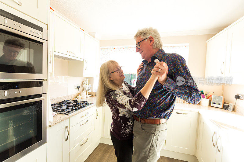 快乐的高年级情侣一起在厨房跳舞