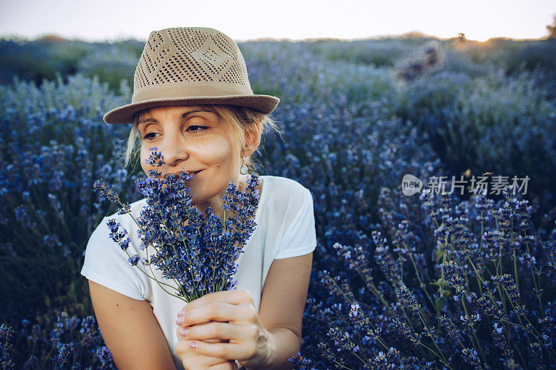 在薰衣草地里成熟的金发女郎。