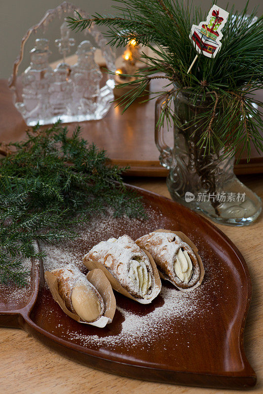 圣诞餐桌-糖霜粉落在奶油煎饼卷上，红木托盘装饰针叶树的树枝