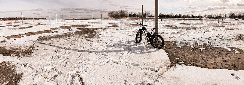 冬天在湖边的沙滩上骑着胖自行车。