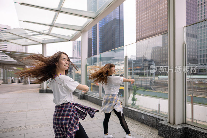 年轻的女性朋友在城市里跳舞