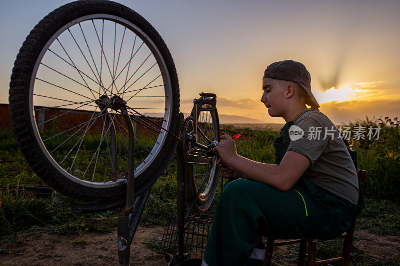 十几岁的男孩，一个在自行车修理店更换链条的实习生