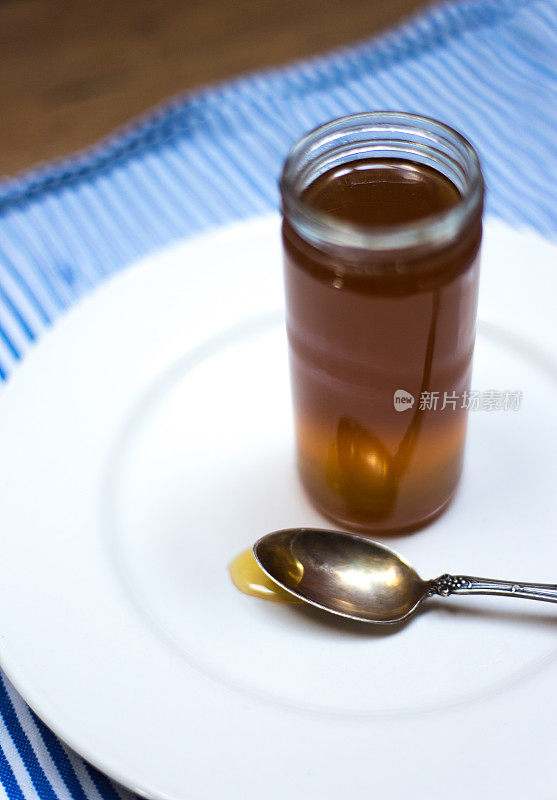 蜂蜜和古董勺子的罐子特写