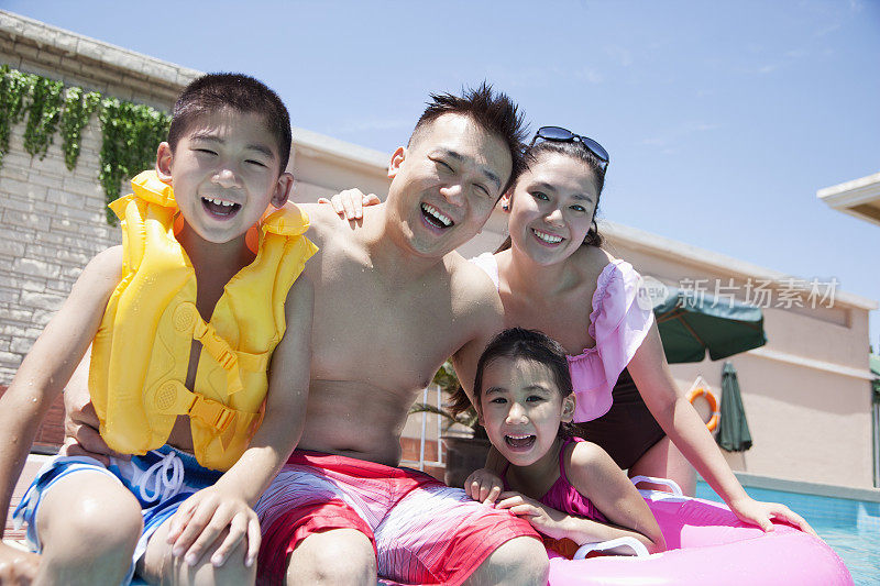 全家福，母亲，父亲，女儿和儿子，在泳池边微笑