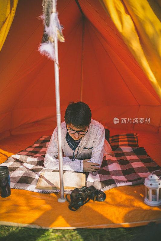 露营员在帐篷里读旅游行会书