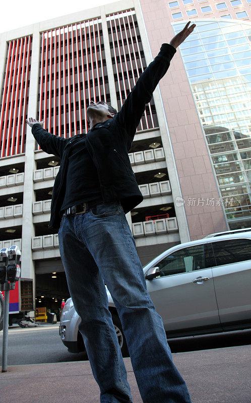 一名男子向市中心的天空举起双手
