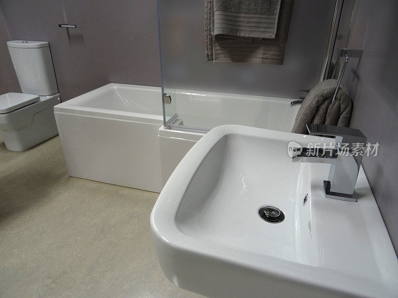 现代浴室，白色l型淋浴，玻璃淋浴屏，壁挂式面盆