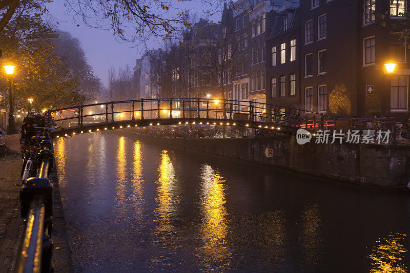 在一个雾蒙蒙的秋天傍晚，阿姆斯特丹运河上的桥