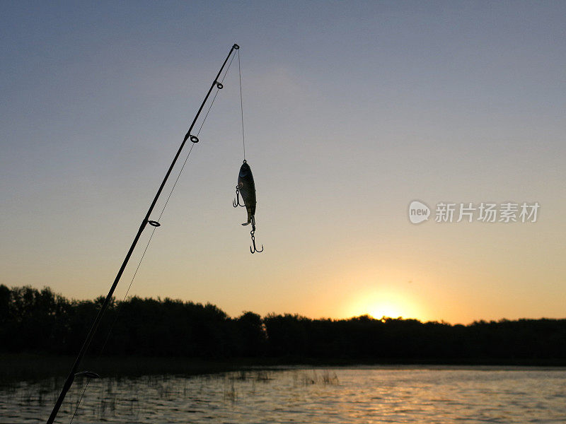 鱼竿杆，曲柄鱼饵饵剪影，清晨日出后的海岸