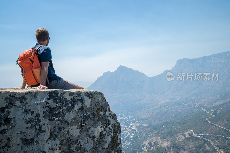 一个年轻人在开普敦山顶上看风景