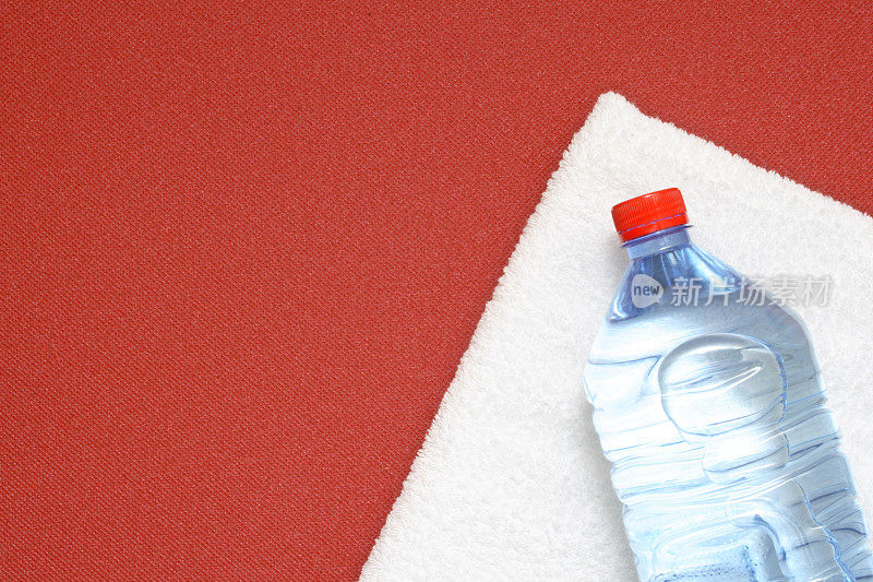 毛巾和垫子上的一瓶水