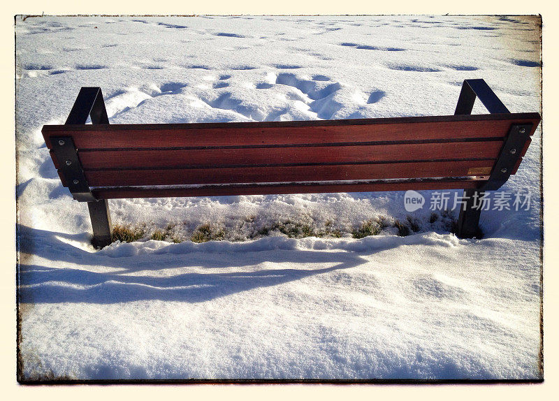 雪地里一条深褐色的公园长椅