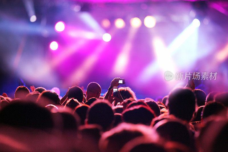 一群年轻人在紫光下听音乐会
