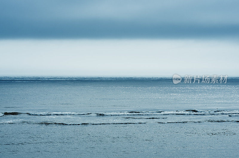 戏剧性的多云天空在黑暗的水面涟漪海面