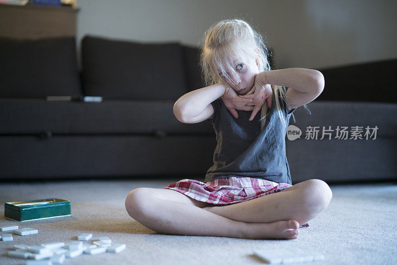 小女孩在地上玩多米诺骨牌