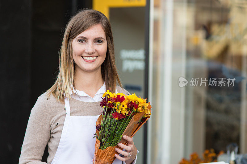 企业家兼老板站在她的花店外面