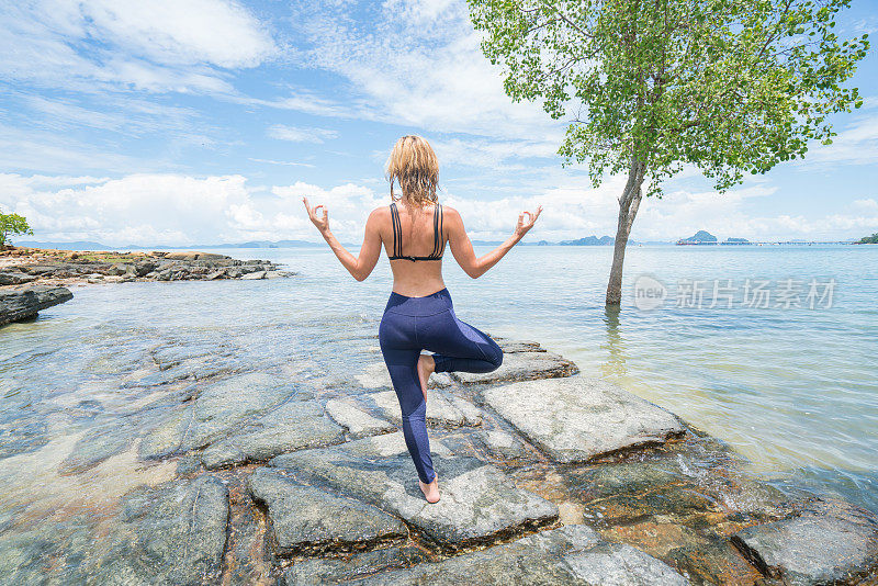 女性在海上岩石上练习瑜伽