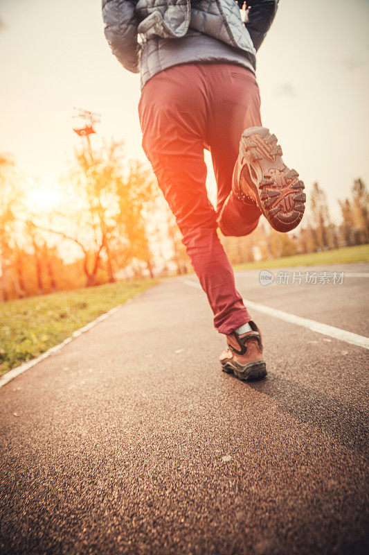 在体育场跑道上跑步的女人