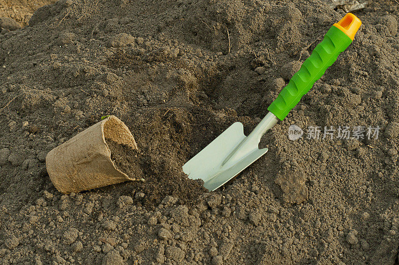 绿色的铲子和泥炭花盆，用于在地上育苗