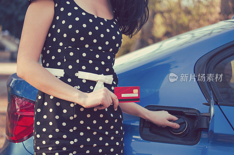 一个女人用信用卡打开她的新车油箱的特写
